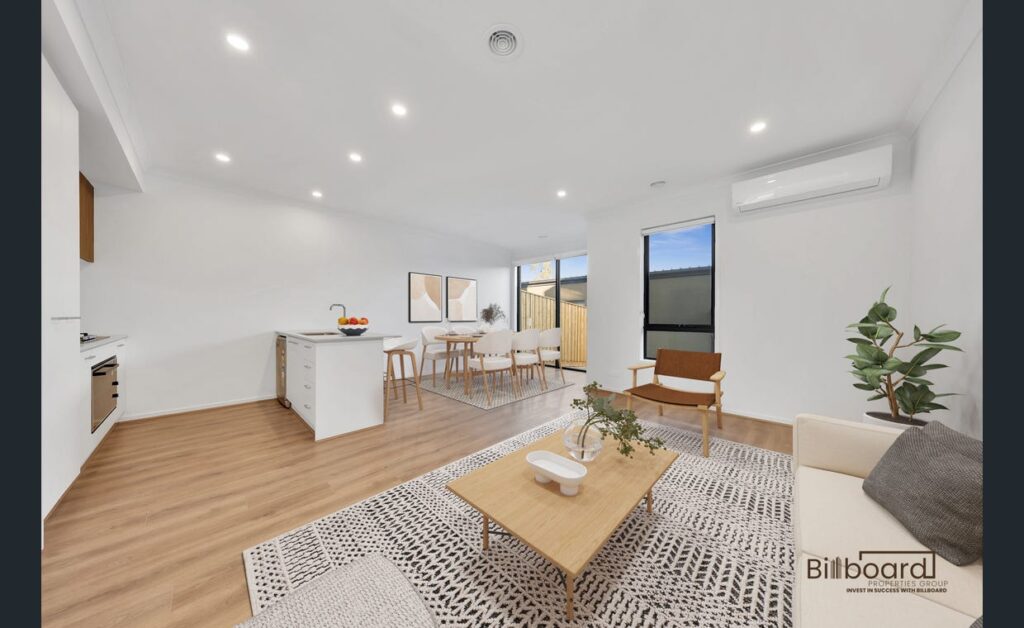 Modern furnished open plan living and dining area with timber flooring, white kitchen island, and contemporary interior styling in a Melbourne home.