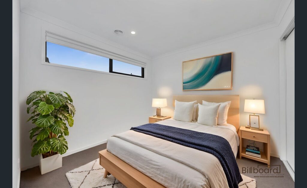 Modern furnished bedroom with wooden bed frame, bedside lamps, indoor plant and soft neutral styling in a contemporary Melbourne home.