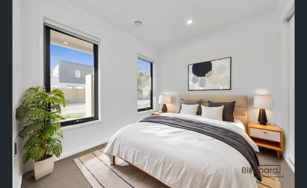 Beautifully styled bedroom with modern decor, indoor plant, natural light and neutral colour palette in a Melbourne home.