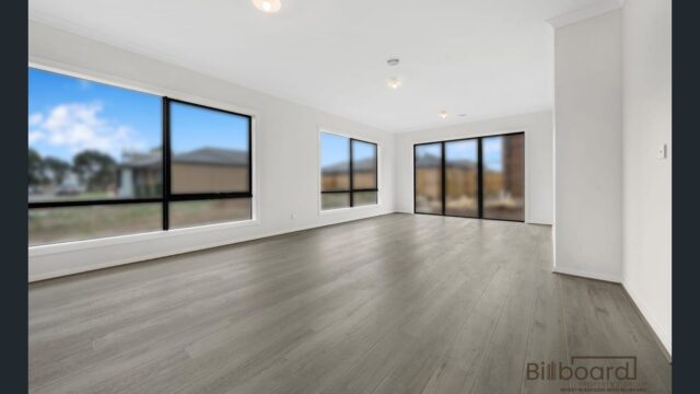 Bright open living space with timber flooring, large windows and sliding glass doors allowing natural light inside a modern Melbourne home.