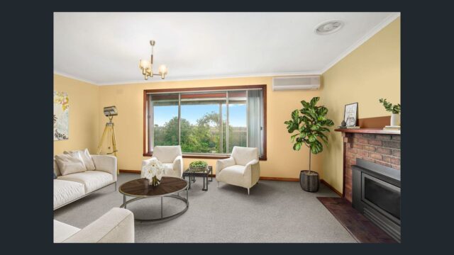 Spacious living room with fireplace, modern furniture, indoor plant and large window overlooking green countryside views.