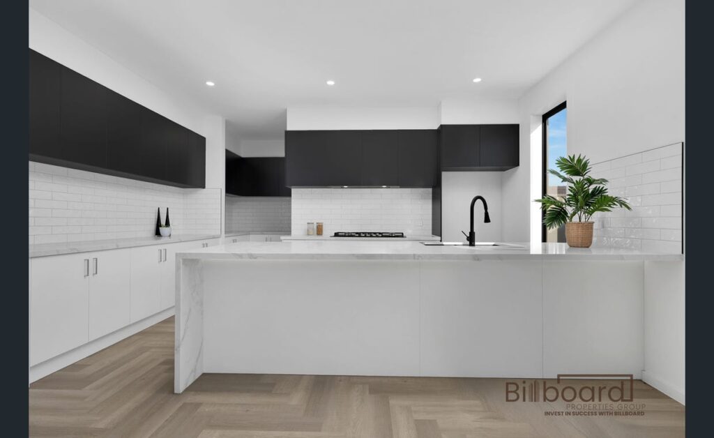 Contemporary kitchen featuring black upper cabinets, white lower cabinets, and a marble countertop.