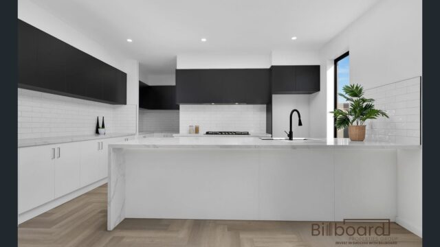 Contemporary kitchen featuring black upper cabinets, white lower cabinets, and a marble countertop.
