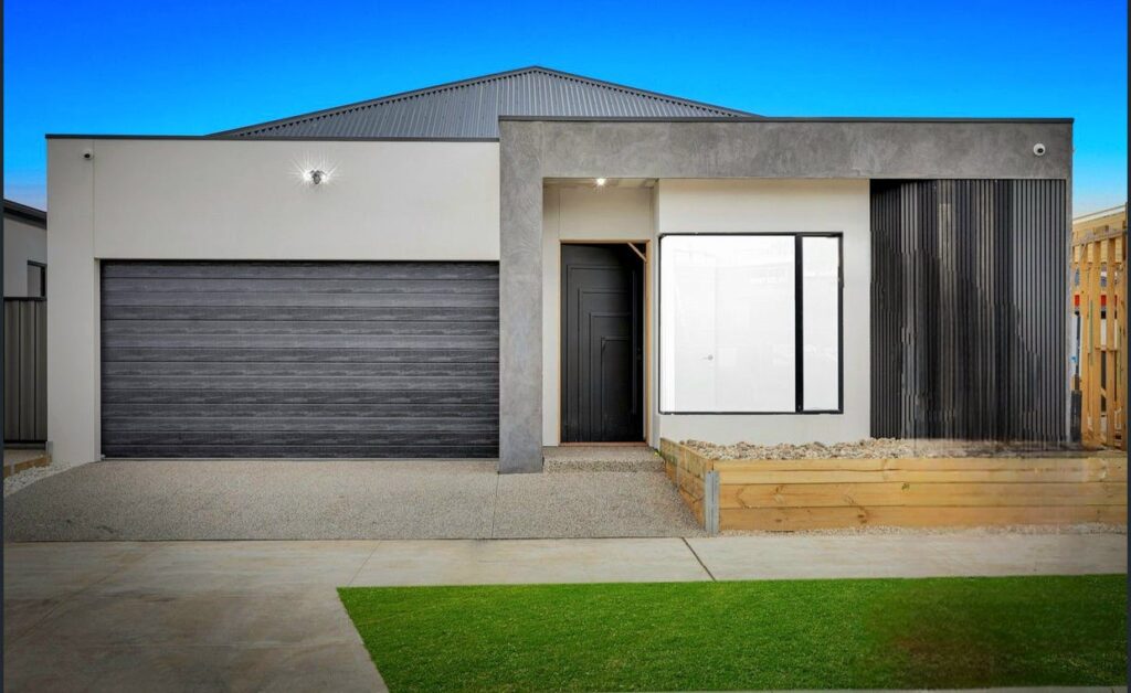 Contemporary single-story home with a gray facade and a black garage door.