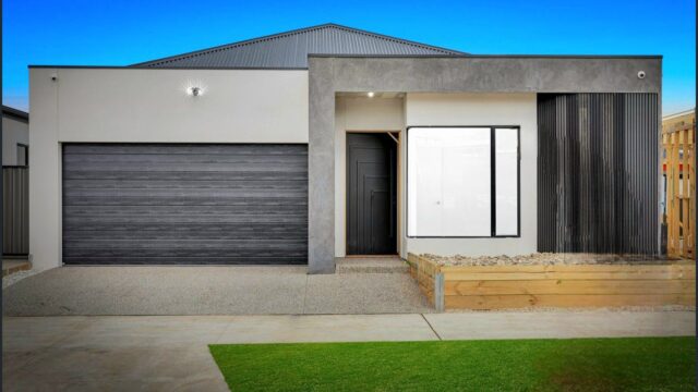 Contemporary single-story home with a gray facade and a black garage door.