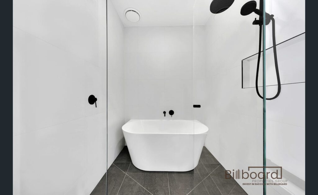 Modern minimalist bathroom featuring a freestanding bathtub, black matte fixtures and tiled flooring in a contemporary Melbourne property.