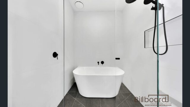 Modern minimalist bathroom featuring a freestanding bathtub, black matte fixtures and tiled flooring in a contemporary Melbourne property.